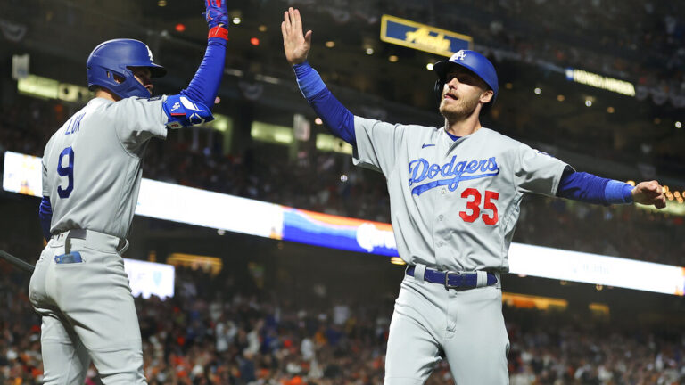 Los Angeles Dodgers' Cody Bellinger (35) is congratulated by Gavin Lux after scoring against the San Francisco Giants during the sixth inning of Game 2 of a baseball National League Division Series Saturday, Oct. 9, 2021, in San Francisco. (AP Photo/John Hefti)