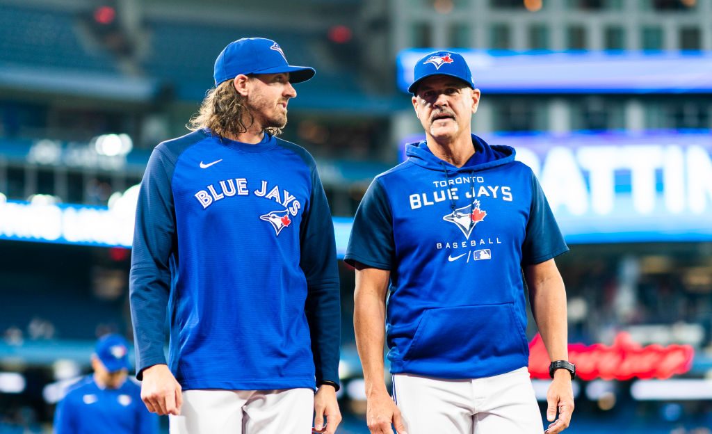 Kevin Gausman #34 of the Toronto Blue Jays walks to the dugout with pitching coach Pete Walker before playing the Boston Red Sox in their MLB game at the Rogers Centre.