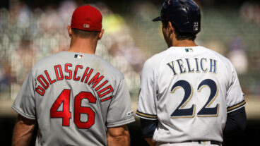 Paul Goldschmidt #46 of the St. Louis Cardinals and Christian Yelich #22 of the Milwaukee Brewers meet at first base in the eighth inning at Miller Park.