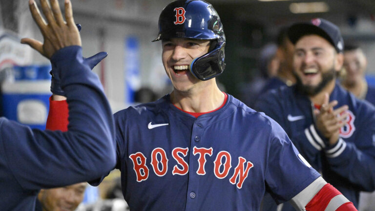 Tyler O'Neill of the Boston Red Sox high fives teammates after a solo home run against the Los Angeles Angels in the second inning of a baseball game at Angel Stadium.