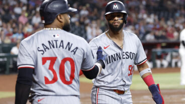 Willi Castro #50 of the Minnesota Twins high fives Carlos Santana #30 after scoring a run during the second inning against the Arizona Diamondbacks at Chase Field.