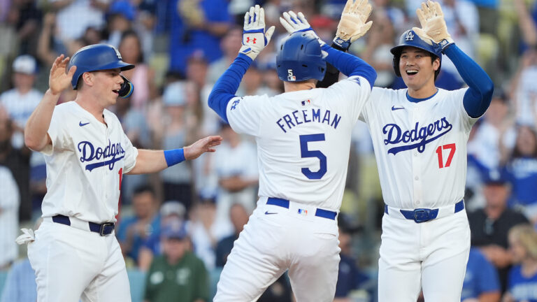 Freddie Freeman #5 of the Los Angeles Dodgers celebrates with teammates Shohei Ohtani #17 and Will Smith #16 after hitting a three run home run against the Arizona Diamondbacks during the first inning at Dodger Stadium.