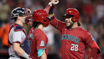 Eugenio Suárez of the Arizona Diamondbacks high fives Corbin Carroll #7 after hitting a solo home run against the Atlanta Braves during the fifth inning of the MLB game at Chase Field.