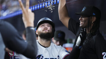 Jake Burger of the Miami Marlins celebrates with teammates in the dugout after hitting a home run against the Cincinnati Reds during the fifth inning at loanDepot park.