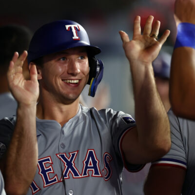 Wyatt Langford of the Texas Rangers celebrates runs scored with teammates in the dugout in during the ninth inning against the Los Angeles Angels at Angel Stadium of Anaheim.