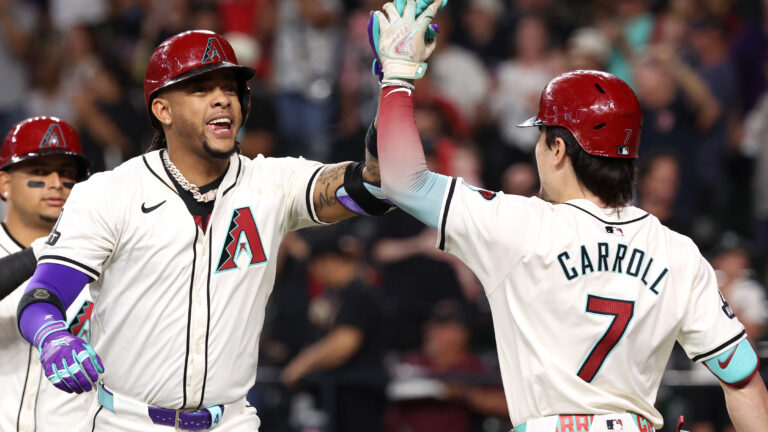 Ketel Marte of the Arizona Diamondbacks high fives Corbin Carroll after hitting a two-run home run during the fourth inning against the San Diego Padres at Chase Field.