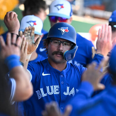 CLEARWATER, FLORIDA - MARCH 17: Davis Schneider #36 of the Toronto Blue Jays celebrates with teammates in the dugout after hitting a solo home run during the third inning of a spring training game against the Philadelphia Phillies at BayCare Ballpark on March 17, 2025 in Clearwater, Florida. (Photo by Nick Cammett/Getty Images)