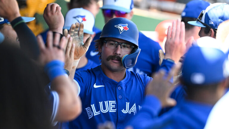 CLEARWATER, FLORIDA - MARCH 17: Davis Schneider #36 of the Toronto Blue Jays celebrates with teammates in the dugout after hitting a solo home run during the third inning of a spring training game against the Philadelphia Phillies at BayCare Ballpark on March 17, 2025 in Clearwater, Florida. (Photo by Nick Cammett/Getty Images)