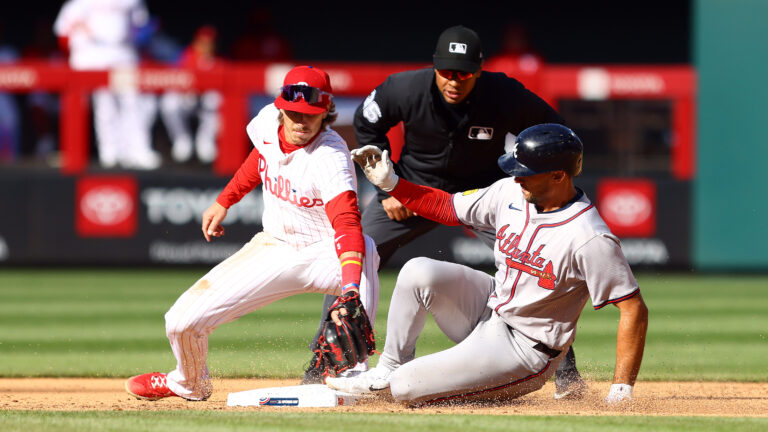 Matt Olson of the Atlanta Braves slides past Bryson Stott #5 of the Philadelphia Phillies after hitting a double during the sixth inning at Citizens Bank Park.