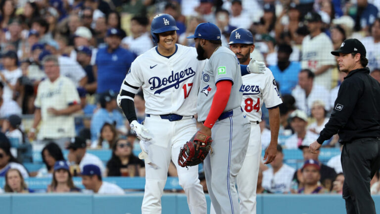 LOS ANGELES, CALIFORNIA - AUGUST 8: Shohei Ohtani #17 of the Los Angeles Dodgers is greeted at first base by Vladimir Guerrero Jr. #27 of the Toronto Blue Jays after hitting a base hit against pitcher Max Scherzer #31 during the first inning at Dodger Stadium on August 8, 2025 in Los Angeles, California. (Photo by Kevork Djansezian/Getty Images)