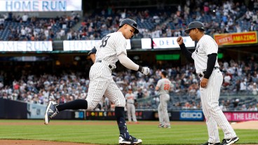 Aaron Judge of the New York Yankees celebrates his home run during the first inning against the Baltimore Orioles with third base coach Luis Rojas at Yankee Stadium.