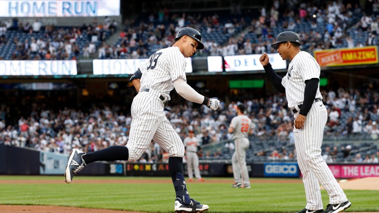 Aaron Judge of the New York Yankees celebrates his home run during the first inning against the Baltimore Orioles with third base coach Luis Rojas at Yankee Stadium.