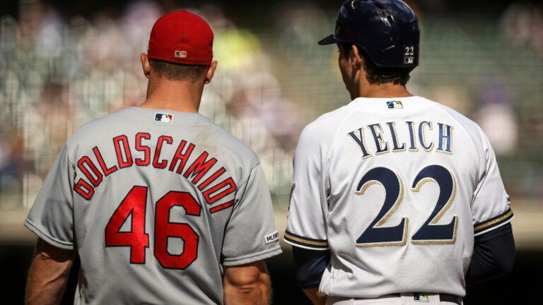 Paul Goldschmidt #46 of the St. Louis Cardinals and Christian Yelich #22 of the Milwaukee Brewers meet at first base in the eighth inning at Miller Park.