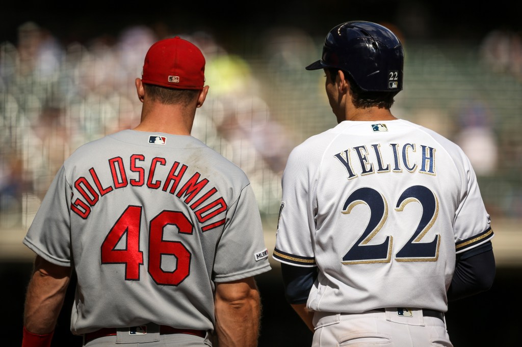 Paul Goldschmidt #46 of the St. Louis Cardinals and Christian Yelich #22 of the Milwaukee Brewers meet at first base in the eighth inning at Miller Park.