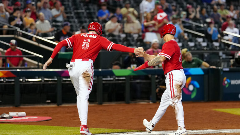 Freddie Freeman of Team Canada his greeted by teammate Tyler O'Neill after scoring a run in the first inning during Game 3 of Pool C between Team Great Britain and Team Canada at Chase Field.