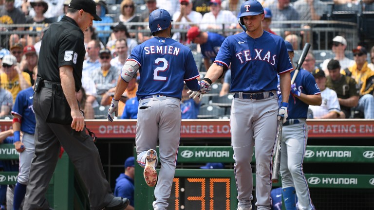 Marcus Semien #2 of the Texas Rangers is met a home plate by Corey Seager #5 after hitting a solo home run in the first inning during the game against the Pittsburgh Pirates at PNC Park.