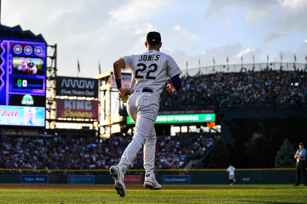 Nolan Jones of the Colorado Rockies runs onto the field to play defense in the fifth inning of a game against the Los Angeles Angels at Coors Field.
