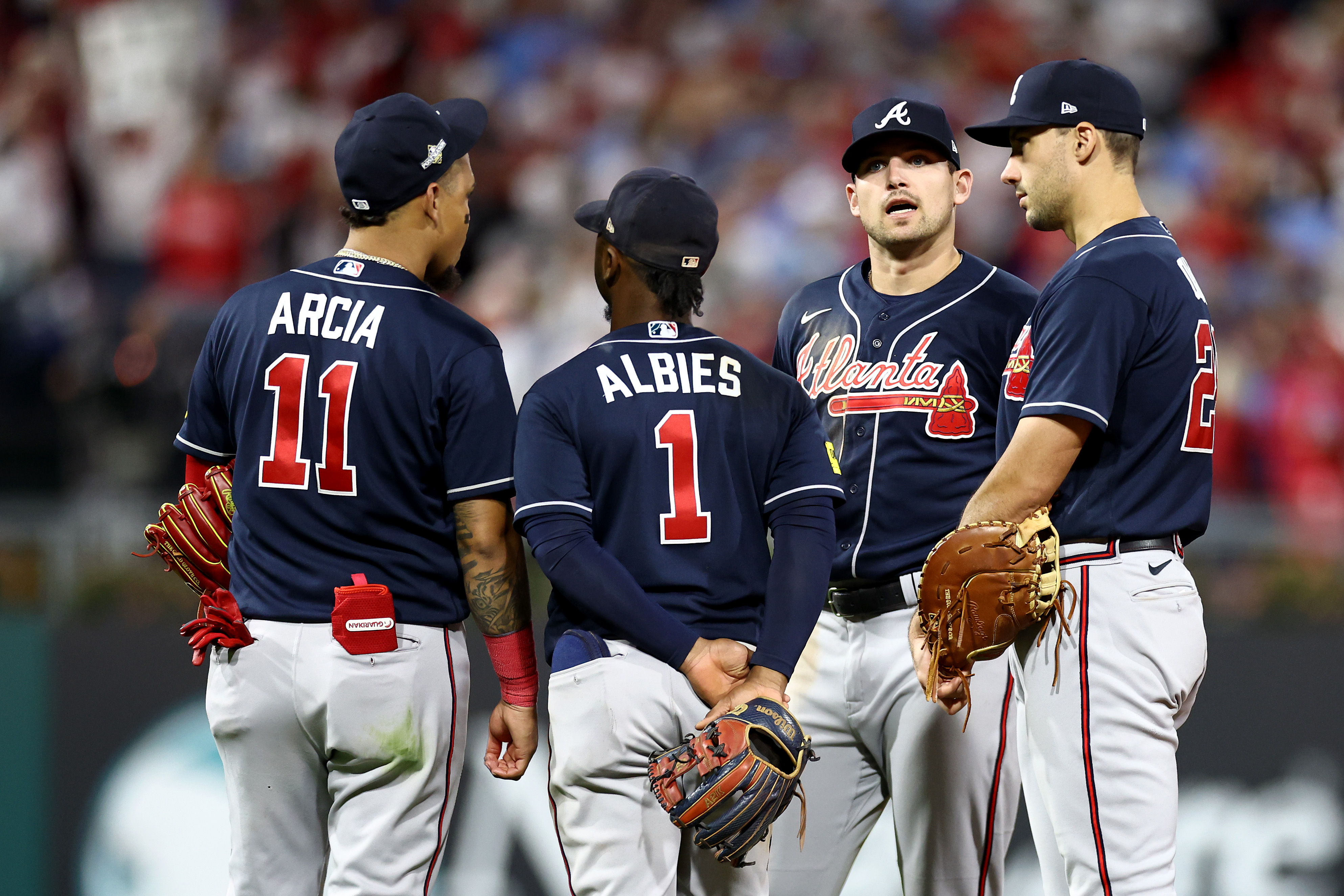 Orlando Arcia #11, Ozzie Albies #1, Austin Riley #27 and Matt Olson #28 of the Atlanta Braves talk against the Philadelphia Phillies during the eighth inning in Game Three of the Division Series at Citizens Bank Park.