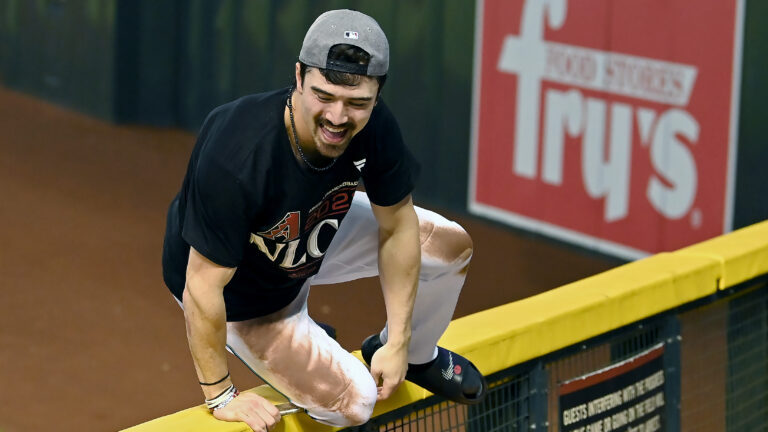 orbin Carroll #7 of the Arizona Diamondbacks climbs the outfield fence after beating the Los Angeles Dodgers 4-2 in Game Three of the Division Series at Chase Field.