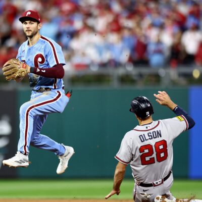 Trea Turner of the Philadelphia Phillies turns a double play past Matt Olson of the Atlanta Braves in the fourth inning during Game Four of the Division Series at Citizens Bank Park.