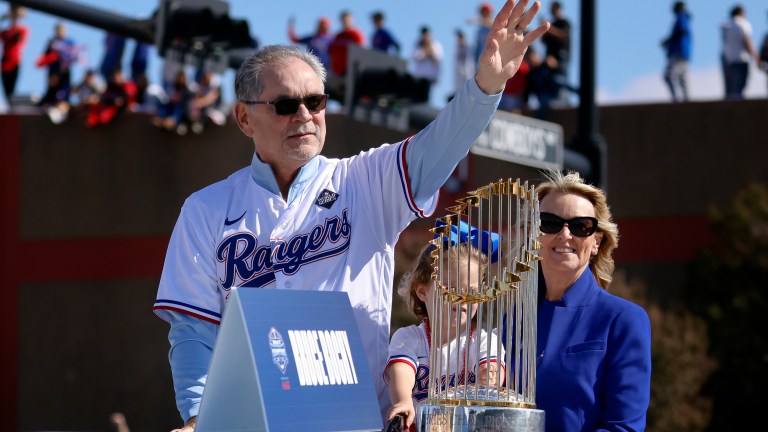 Texas Rangers manager Bruce Bochy and his wife Kim Seib ridie with the World Series trophy and wave to fans lining the street and buildings during the World Series Victory Parade outside Globe Life Field on November 3, 2023 in Arlington, Texas. The Rangers defeated the Arizona Diamondbacks, 4-1 at the World Series.