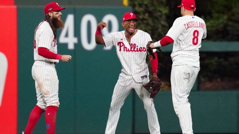 Brandon Marsh #16, Johan Rojas #18 and Nick Castellanos #8 of the Philadelphia Phillies celebrate after the Phillies defeated the Arizona Diamondbacks in Game 2 of the NLCS at Citizens Bank Park.