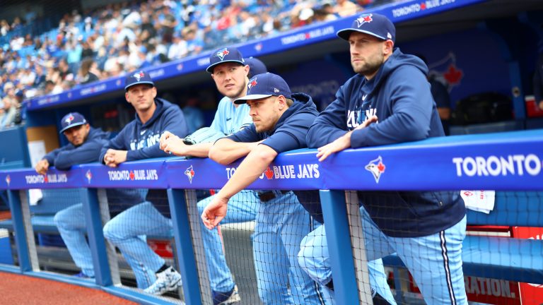 Nate Pearson, Erik Swanson, and Tim Mayza of the Toronto Blue Jays look on from the dugout prior to a game against the Houston Astros at Rogers Centre.