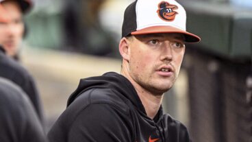 Baltimore Orioles starting pitcher Kyle Bradish stands in the dugout during the Washington Nationals versus the Baltimore Orioles at Oriole Park at Camden Yards.