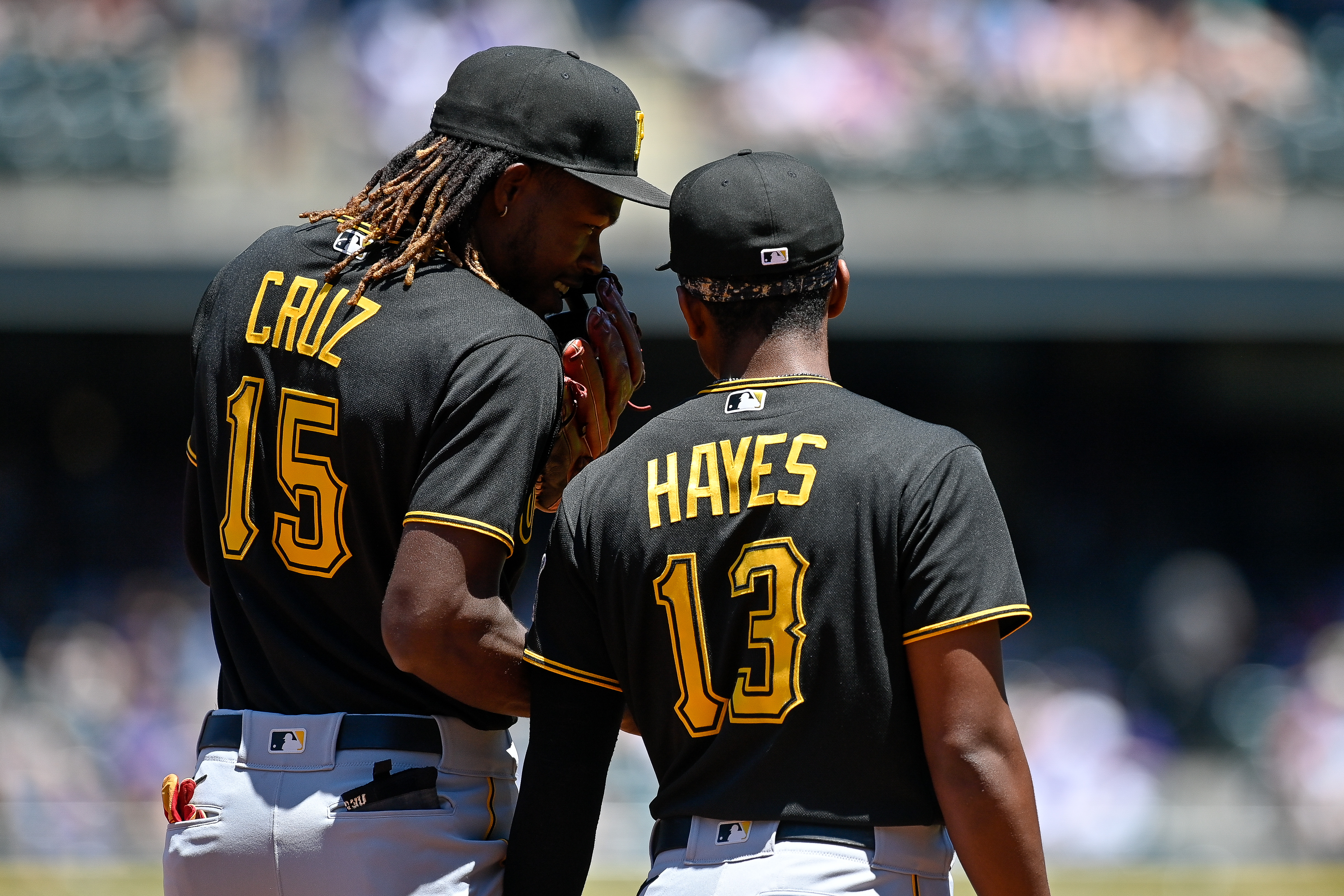 Pittsburgh Pirates shortstop Oneil Cruz (15) has a word with third baseman Ke'Bryan Hayes (13) during a game between the Pittsburgh Pirates and the Colorado Rockies at Coors Field.