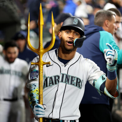 Julio Rodriguez of the Seattle Mariners celebrates his solo home run with the trident prop during the fourth inning against the Texas Rangers.
