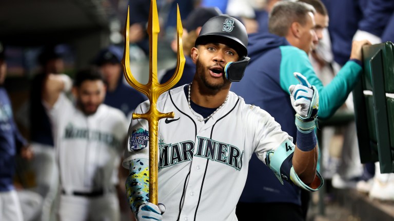 Julio Rodriguez of the Seattle Mariners celebrates his solo home run with the trident prop during the fourth inning against the Texas Rangers.