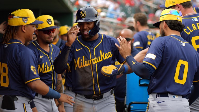 Jackson Chourio of the Milwaukee Brewers celebrates with teammates after scoring a run in the first inning during a spring training game against the Cincinnati Reds at Goodyear Ballpark.