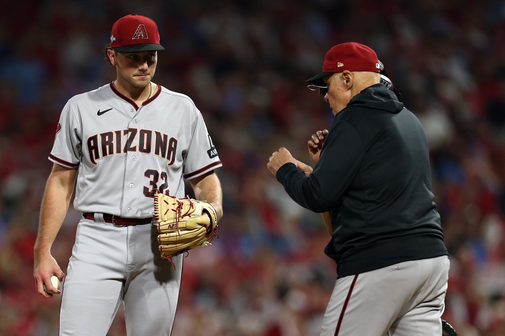 Brandon Pfaadt of the Arizona Diamondbacks reacts as pitching coach Brent Strom #72 talks with him against the Philadelphia Phillies during the fourth inning in Game Seven of the Championship Series at Citizens Bank Park.