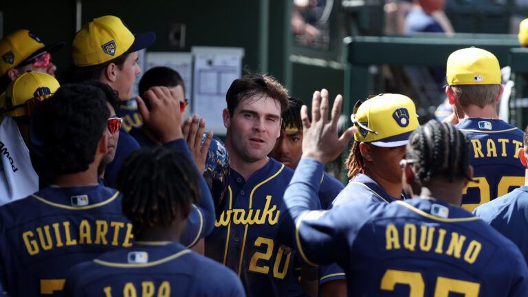 Tyler Black of the Milwaukee Brewers is greeted in the dugout after scoring a run in the third inning during the 2024 Spring Breakout Game between the Milwaukee Brewers and the Kansas City Royals at Surprise Stadium.