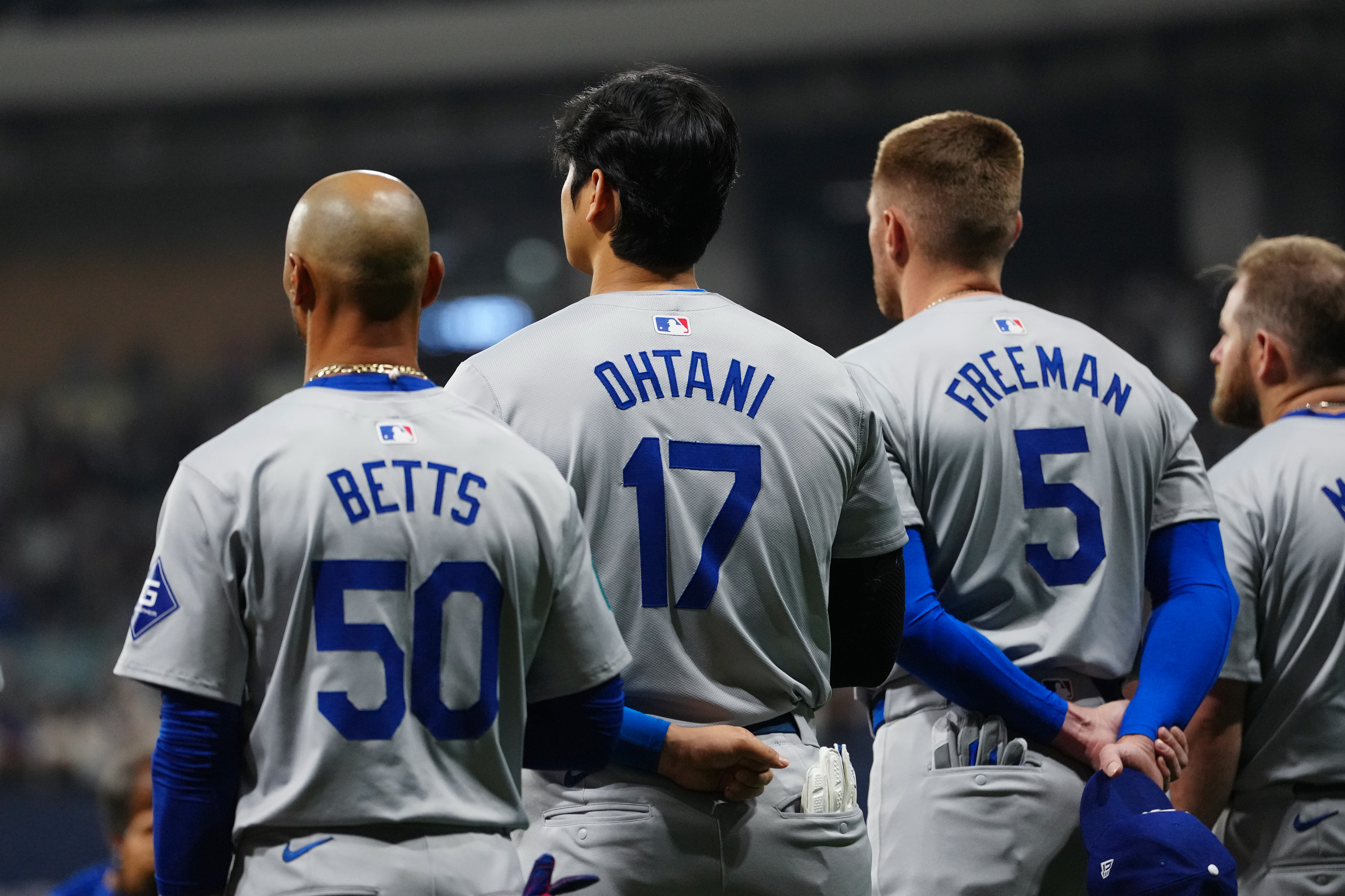 Mookie Betts #50, Shohei Ohtani #17 and Freddie Freeman #5 of the Los Angeles Dodgers look on during the national anthem prior to the 2024 Seoul Series game between the Los Angeles Dodgers and the San Diego Padres at Gocheok Sky Dome.