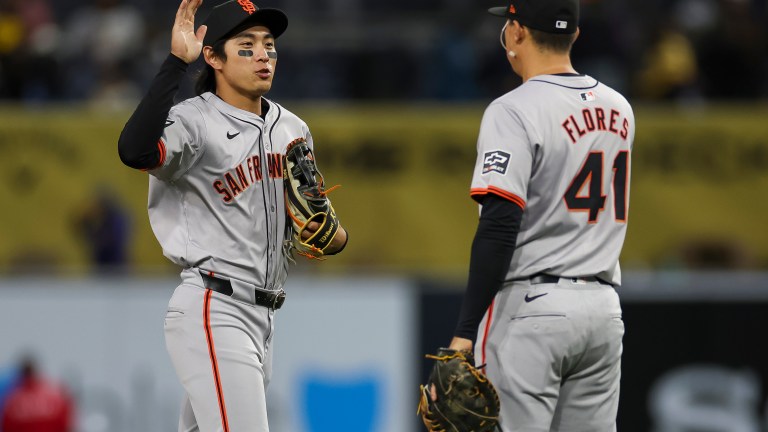 Jung Hoo Lee of the San Francisco Giants celebrates a team victory with Wilmer Flores during a game against the San Diego Padres at PETCO Park.