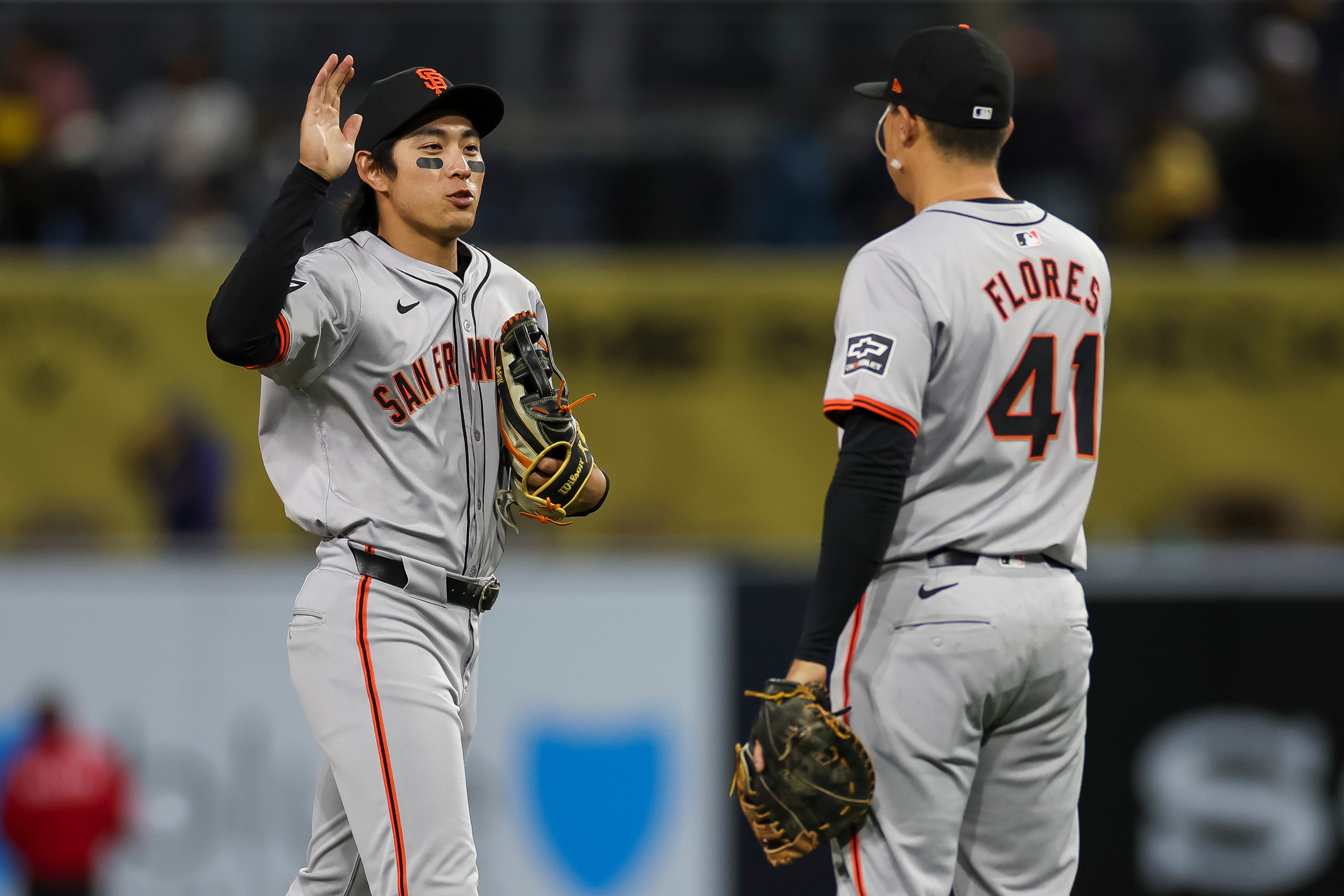Jung Hoo Lee of the San Francisco Giants celebrates a team victory with Wilmer Flores during a game against the San Diego Padres at PETCO Park.
