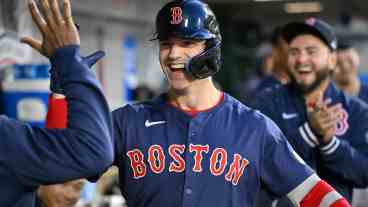 Tyler O'Neill of the Boston Red Sox high fives teammates after a solo home run against the Los Angeles Angels in the second inning of a baseball game at Angel Stadium.