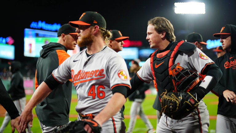 Craig Kimbrel #46 and Adley Rutschman #35 of the Baltimore Orioles celebrate a win with teammates after the game between the Baltimore Orioles and the Boston Red Sox at Fenway Park.