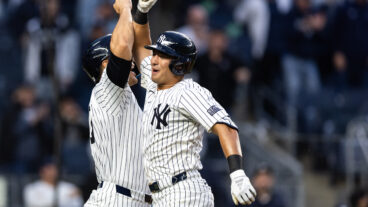 Anthony Volpe #11 of the New York Yankees celebrates with Giancarlo Stanton #27 of the New York Yankees after hitting a home run during the fourth inning of the game against the Miami Marlins at Yankee Stadium.