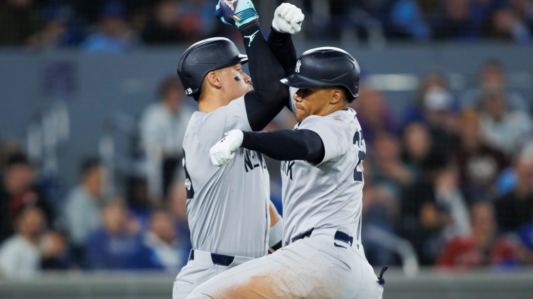 Juan Soto #22 of the New York Yankees celebrates with Aaron Judge #99 on a solo home run in the eighth inning of their MLB game against the Toronto Blue Jays at Rogers Centre.
