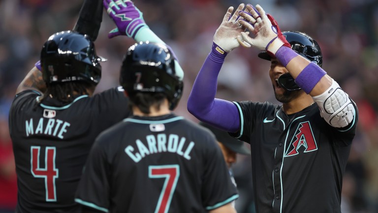 Lourdes Gurriel Jr. #12 of the Arizona Diamondbacks high fives Ketel Marte #4 and Corbin Carroll #7 after hitting a three-un home run against the St. Louis Cardinals during the MLB game at Chase Field.