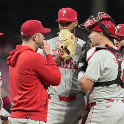 Cristopher Sánchez of the Philadelphia Phillies speaks with teammates at the pitcher's mound during the third inning of a baseball game against the Cincinnati Reds at Great American Ball Park.