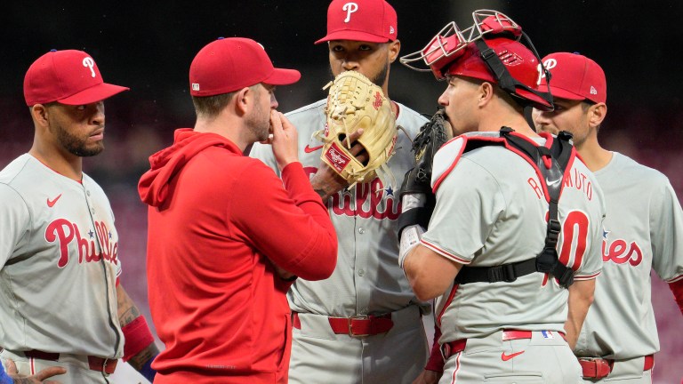 Cristopher Sánchez of the Philadelphia Phillies speaks with teammates at the pitcher's mound during the third inning of a baseball game against the Cincinnati Reds at Great American Ball Park.