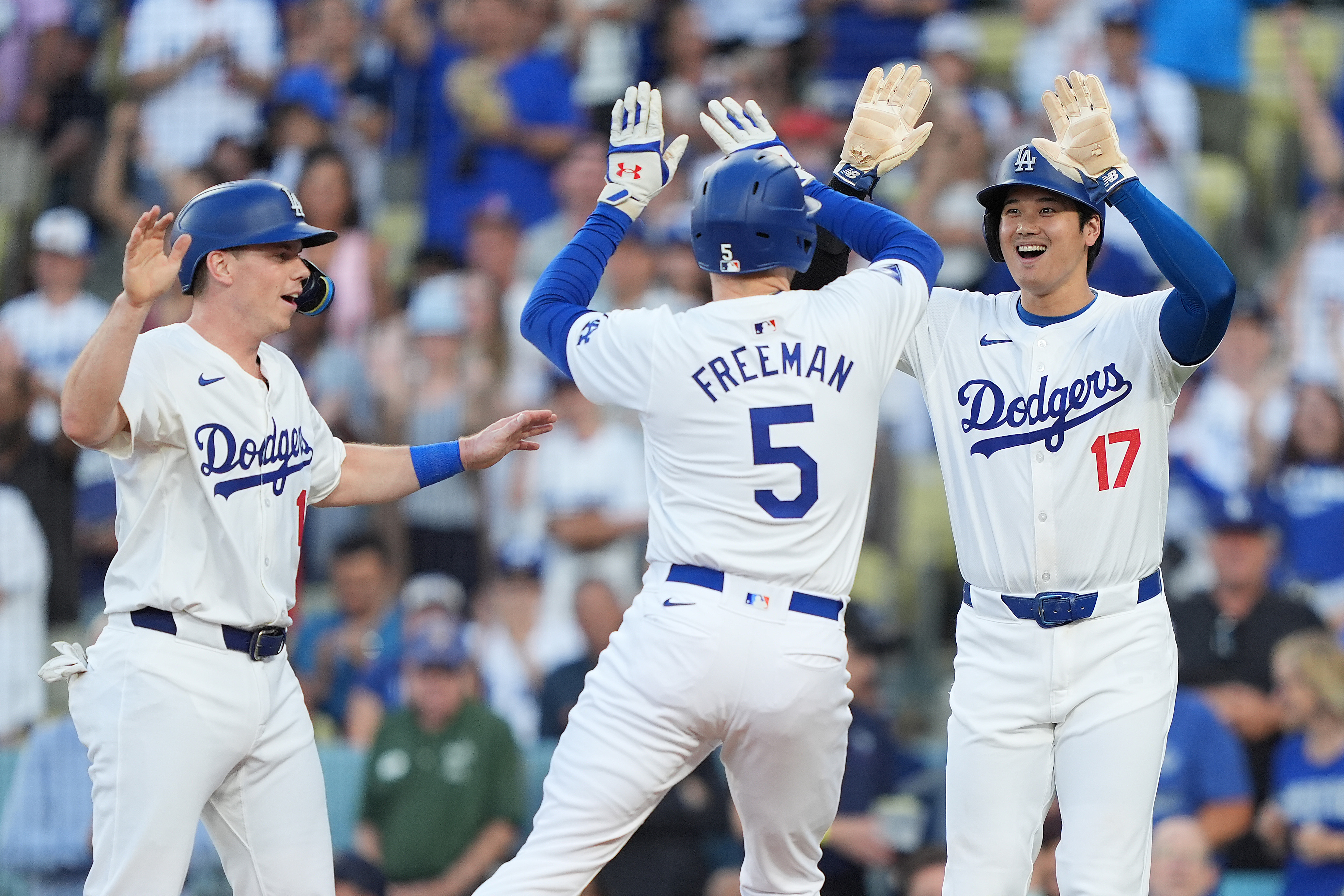 Freddie Freeman #5 of the Los Angeles Dodgers celebrates with teammates Shohei Ohtani #17 and Will Smith #16 after hitting a three run home run against the Arizona Diamondbacks during the first inning at Dodger Stadium.