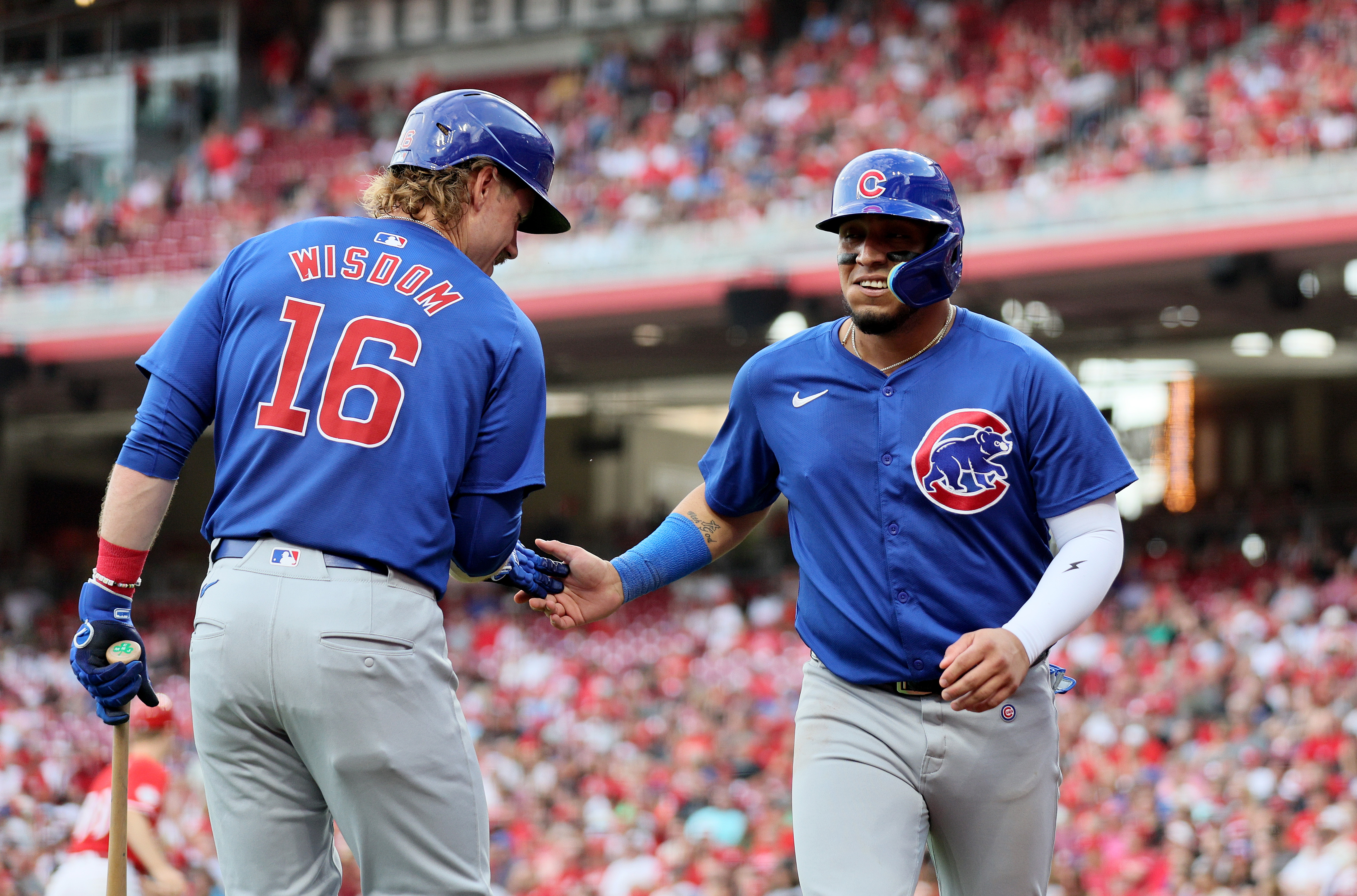 Patrick Wisdom #16 and Isaac Paredes #17 of the Chicago Cubs celebrate after Paredes scored in the against the Cincinnati Reds at Great American Ball Park.