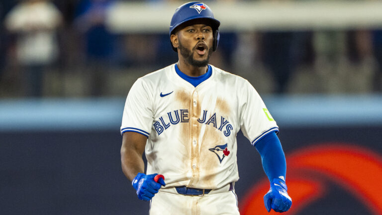 Blue Jays infielder Luis De Los Santos celebrates a base hit on second.