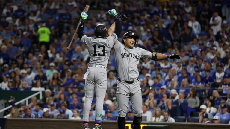 KANSAS CITY, MO - OCTOBER 9: Giancarlo Stanton #27 of the New York Yankees high fives Jazz Chisholm Jr. #13 after hitting a home run in the eighth inning of Game Three of the Division Series against the Kansas City Royals at Kauffman Stadium on October 9, 2024 in Kansas City, Missouri. (Photo by New York Yankees/Getty Images)