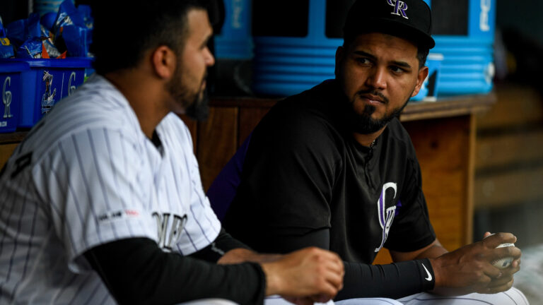 German Marquez #48 has a word with Antonio Senzatela #49 of the Colorado Rockies in the dugout during a game against the Cincinnati Reds.