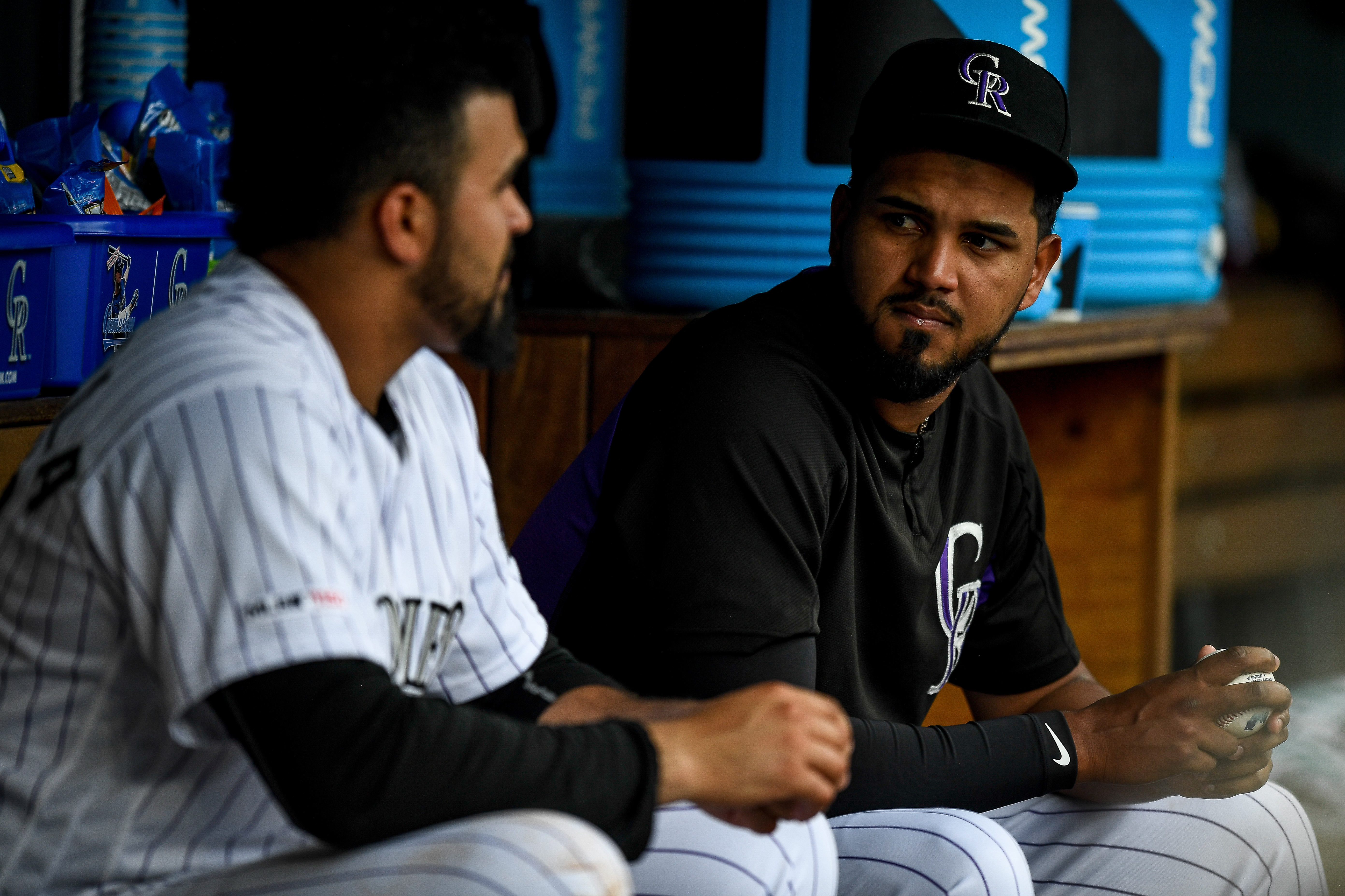 German Marquez #48 has a word with Antonio Senzatela #49 of the Colorado Rockies in the dugout during a game against the Cincinnati Reds.